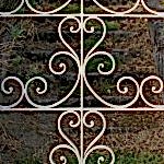 wrought_iron_gate_-_decorative_gate_opens_on_stone_stairs_leading_to_an_abandoned_french_seaside_villa_